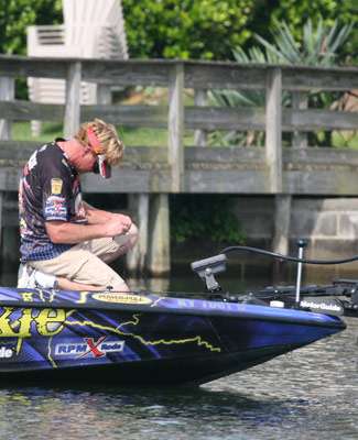 <p>
	Rick Morris kneels on his deck to retie a lure on Day Two of the Evan Williams Bourbon Carolina Clash.</p>
