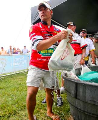 <p>
	 Keith Poche pulls his fish from a holding tank before climbing the steps to the weigh stage. </p>
