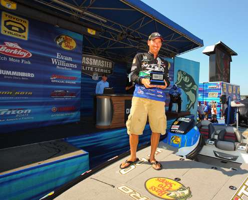<p>
	Ott DeFoe stands in his boat with the 2011 Bassmaster Rookie of the Year trophy.</p>
