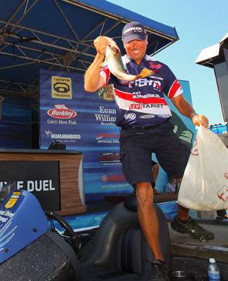 Walker steps from his boat with his biggest bass of the day in hand.
