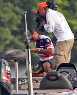<p>
	Walker pulls a bass onto the front deck of his boat on Day Three of the Dixie Duel.</p>
