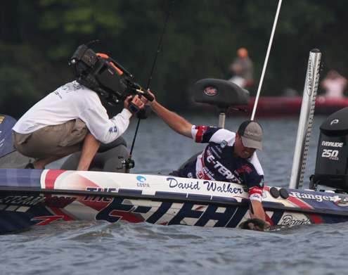 <p>
	Bass firmly cradled, Walker pulls it over the edge and into the boat.</p>
