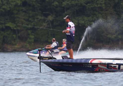 <p>
	A jet ski flies by David Walker as he fishes on Saturday.</p>
