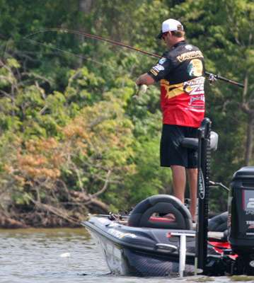 <p>
	Kevin VanDam unhooks a bass that he caught early on Day One.</p>
