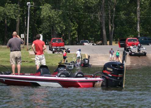 <p>
	Spectators both in a boat and on shore snap pictures of Kevin VanDam on the water.</p>
