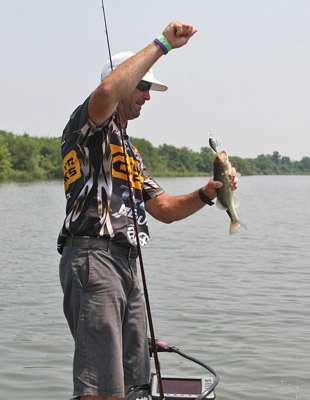 <p>
	Gerald Swindle gets a grip on the bass to try and get the hook out.</p>
