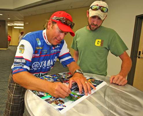 <p>
	Dean Rojas signs a homemade poster for B.A.S.S. fan Justin Manning.</p>
