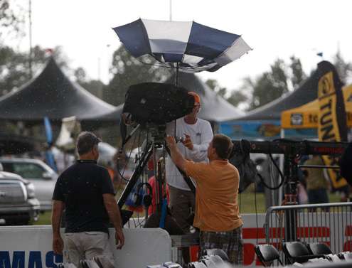 <p>
	 </p>
<p>
	Cameramen work to get their gear covered as the umbrellas turned inside out.</p>
