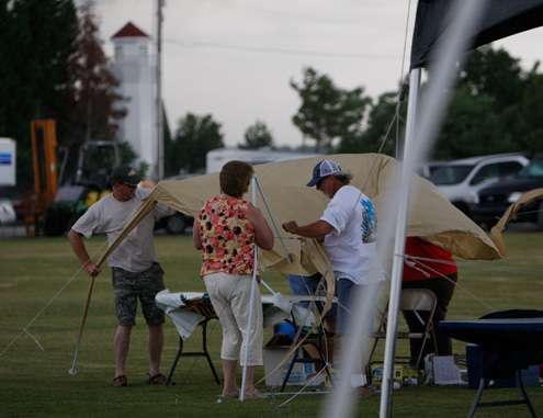 <p>
	 </p>
<p>
	People work to take down a tent before it gets blown away.</p>
