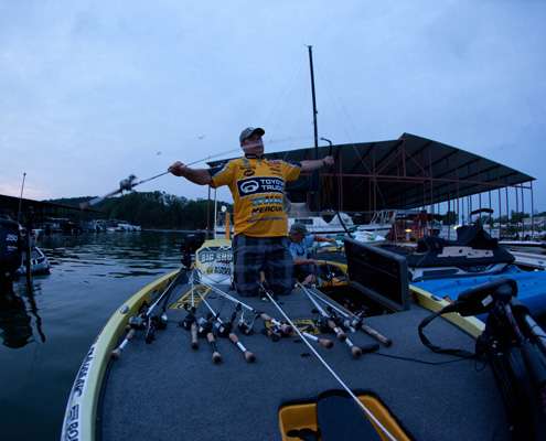 <p>
	Terry Scroggins lines his rod and reels across his boat. </p>
