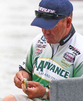 <p>
	Hite ties on a crankbait as he waits for launch.</p>
