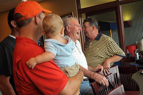 <p>
	Jerry McKinnis laughs with his employees and anglers after tossing out the first pitch.</p>
