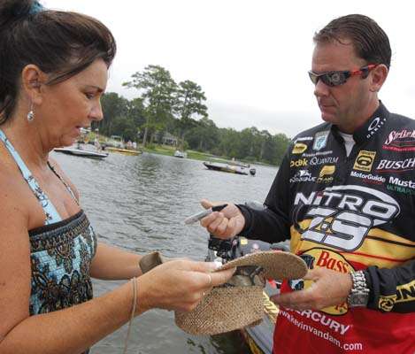 <p>
	Kevin VanDam signs a hat for a fan.</p>
