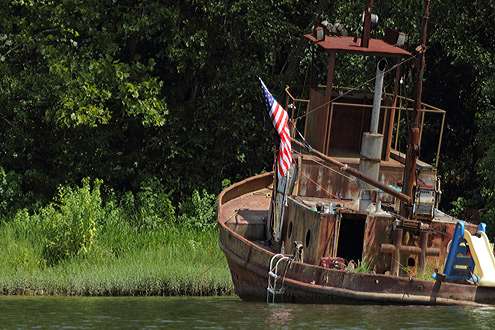 <p>
	 </p>
<p>
	A boat lies half sunken near the banks of the river, but the American flag still flies proudly from its rusty deck.</p>
