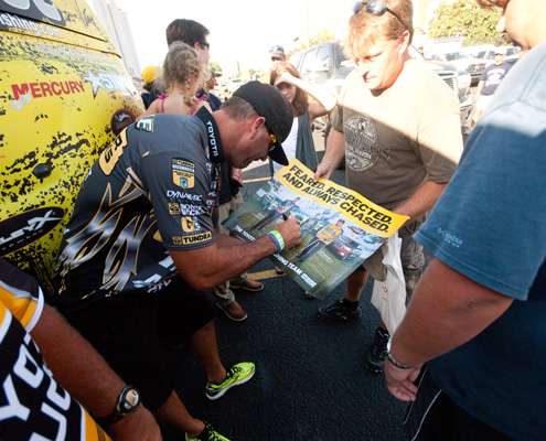 <p>
	Gerald Swindle signs a poster for a fan. </p>
