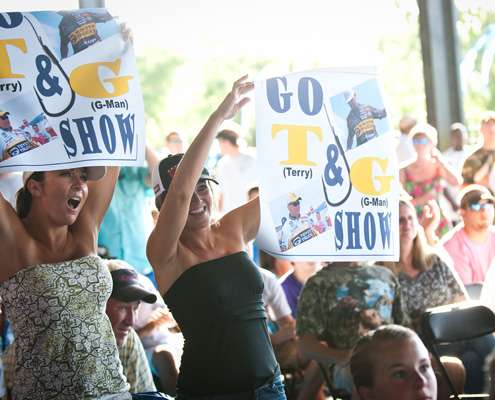 <p>
	Some fans of Swindle and Scroggins cheer and hold signs.</p>
