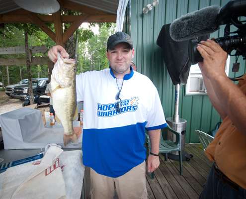 <p>
	Paul Walter holds up their big bass, which weighed in around 4 pounds. </p>
