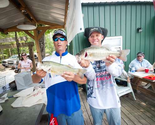 <p>
	John Lightsey and Aaron Martens hold up two of their bass from the day. </p>
