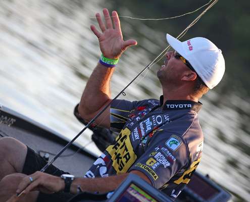 <p>
	Gerald Swindle grabs at his line to retie one of his lures on Friday.</p>
