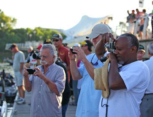 <p>
	Spectators snap pictures on the docks as they watch the take-off.</p>
