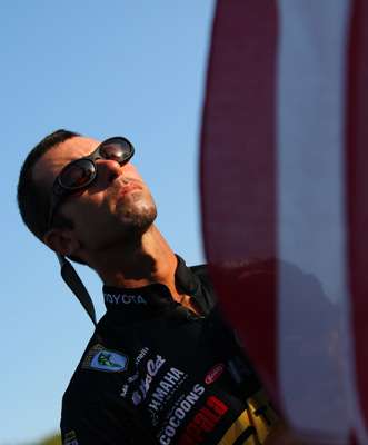 <p>
	Mike Iaconelli stands before the flag as the national anthem is played.</p>
