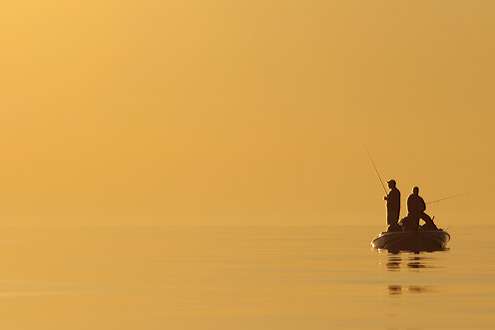 <p>
	An angler is backlit by the early sun on Day Three of competition.</p>
