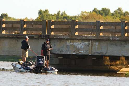 <p>
	Arkansas pro Quincy Houchman makes a cast near a bridge piling, while his co-angler Eric Cooper casts to a weed line along the shoreline. </p>
