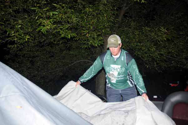 <p>
	Chris Adams takes the cover of his boat before heading to the ramp. He and his dad, Don Adams Jr., both made the Vermont team this year.</p>
