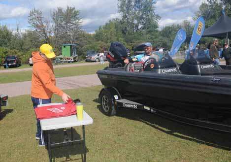 Volunteer Bill Chandler hands out a weigh-in bag to contestant Greg Horne.
