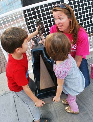 <p>
	James Niggemeyerâs children, Daniel, 6, and Abigail, 3, try to lift the Central Open trophy from Kevin Shortâs wife, Kerry.</p>
