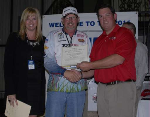 <p>
	Michelle Kilburn of Mercury, left, and Adam Adkisson of Triton, right, present Eddie Plemons, president of the Alabama B.A.S.S. Federation Nation, with a certificate for a boat. Alabama won the boat because the state had the highest finishing angler (Jamie Horton) who ran a Triton Mercury rig during his qualification.</p>
