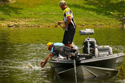 <p>
	Jeff Krietâs co-angler reaches to lip a bass on the final day of fishing on Grand Lake. </p>
