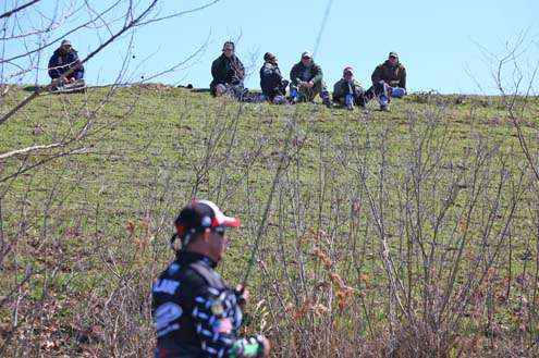 <p>
	A group of fans watch Chris Lane fish from the top of a hill.</p>
