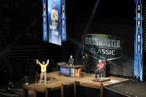 <p>
	Bobby Lane holds up two of his fish for the weigh-in crowd.</p>
