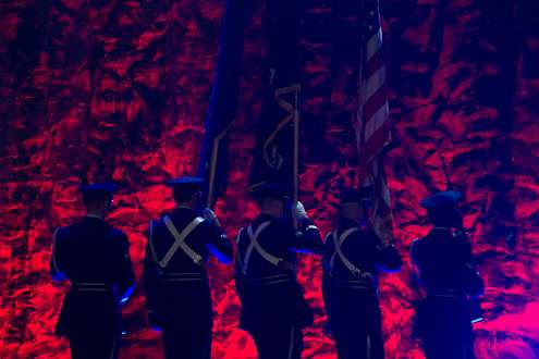 The military color guard walks in formation.
