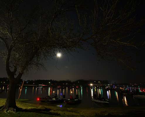 <p>
	A full moon hangs overhead while anglers prepare their boats for take-off.</p>
