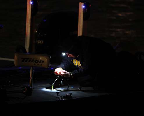 <p>
	An angler works on tackle with the help of a light.</p>
