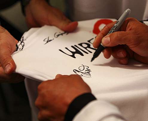 <p>
	Edwin Evers signs a t-shirt for a fan during Media Day.</p>
