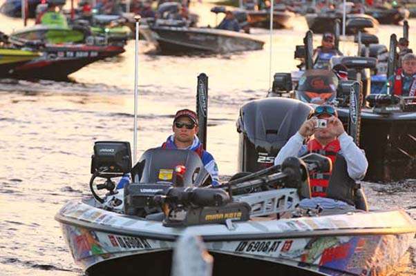 <p>
	Brandon Palaniuk leads a line of boats through the check-out process.</p>
