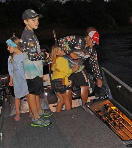 <p>
	Chris Lane gets his rods out of his boat flanked by his children.</p>
