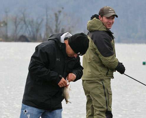 <p>
	UAB unhooks the crankbait from the small bass before turning it loose.</p>
