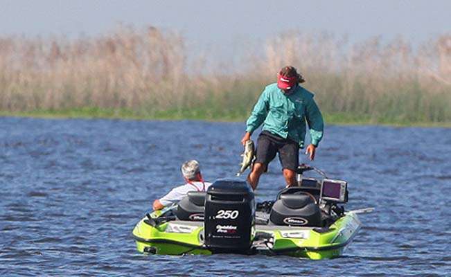 <p>
	Byron Velvick moves to the back of the boat to place a fish in the livewell. </p>
