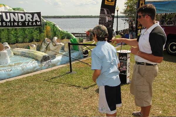 <p>
	Chip Porche helps a young angler sharpen his casting skills in the Toyota booth.</p>
