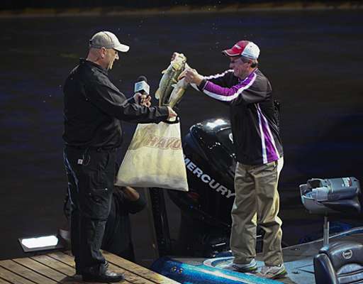 <p>
	Kevin Wirth drops his fish in the bag after he shows the crowd.</p>
