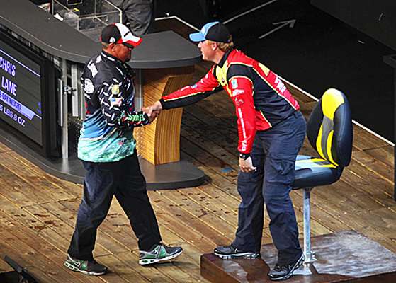 Vinson gives Chris Lane a handshake as Lane mounts the stage to weigh his catch.
