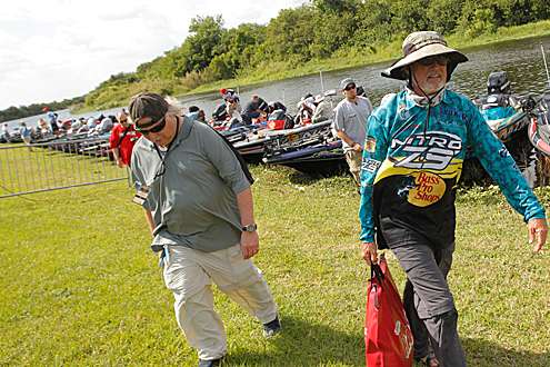 <p>
	Rick Clunn walks from his boat to the weigh-in stage on Day One.</p>
