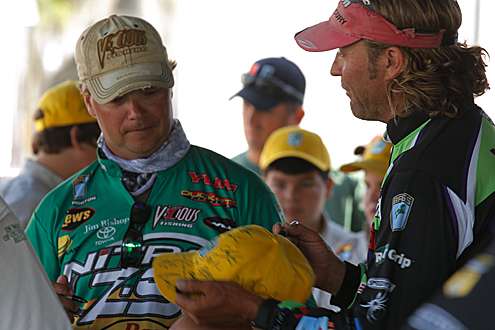 <p>
	Timmy Horton and Byron Velvick sign a hat while waiting to weigh in.</p>
