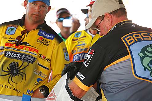 <p>
	Officials check Bobby Lane's fish as he makes his way to the stage.</p>
