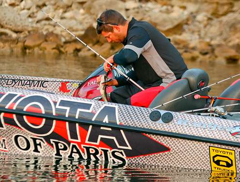 <p>
	Tislau removes the hooks from his first fish of the day. </p>
