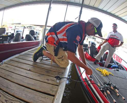 Kyle Ekstrom, a college angler from the University of Illinois, ties the boat up as Hunter Fant looks on.
